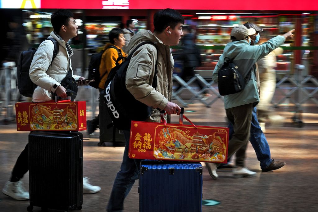 Anak-anak muda bersiap mudik dari stasiun kereta Beijing, China, pada Februari 2024.