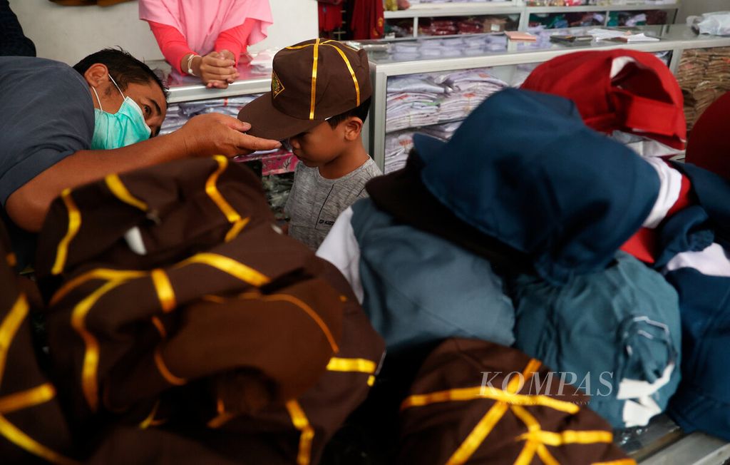 Orangtua yang mengantarkan anaknya untuk mencoba baju seragam di Krapyak, Kota Semarang, Jawa Tengah, Jumat (14/7/2023). 