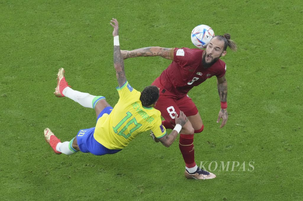 Pemain Brasil Neymar terjatuh saat berebut bola dengan pemain Serbia Nemanja Gudelj di babak fase Grup G Piala Dunia 2022 di Stadion Lusail, Qatar, Jumat (24/11/2022) dinihari WIB. Brasil Menang 2-0.