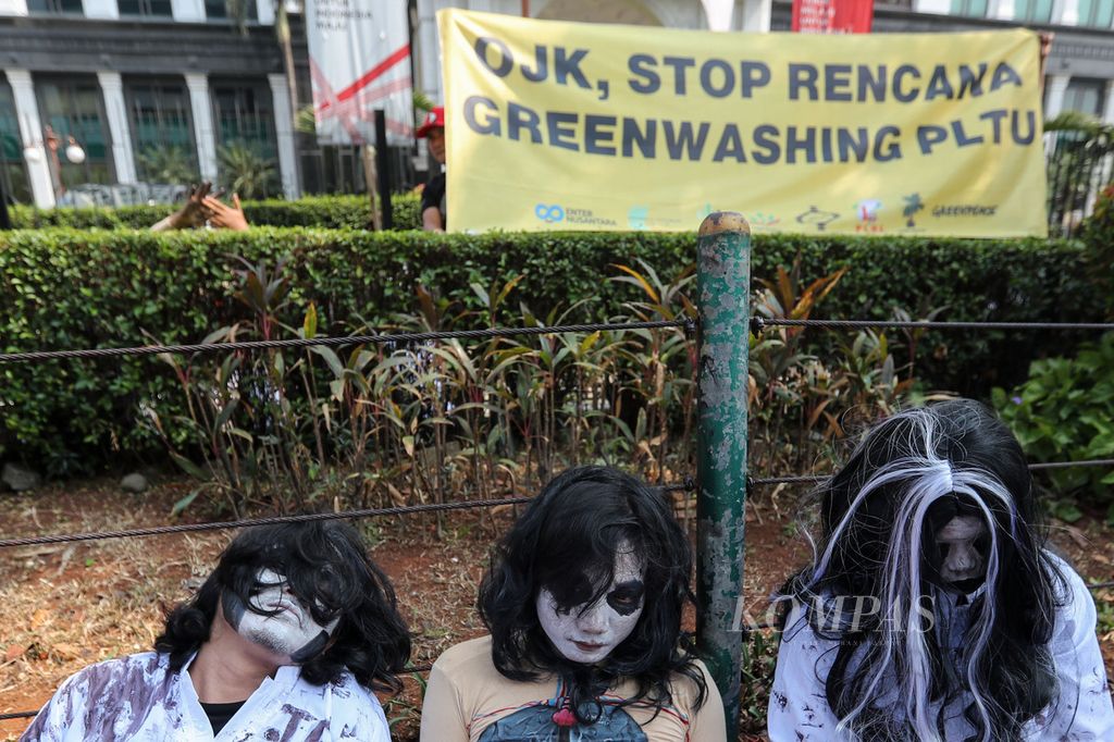 Action participants perform theatrical actions in front of the Financial Services Authority (OJK) Sumitro Djojohadikusumo Building, Jakarta, Friday (15/9/2023).