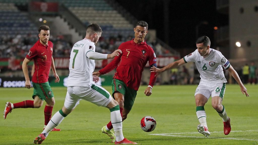Bomber Portugal, Cristiano Ronaldo (tengah), sambil menggiring bola berusaha melalui kepungan dua pemain Irlandia dalam laga kualifikasi Piala Dunia 2022 di Stadion Algarve, Faro, Portugal, Kamis (2/9/2021). Portugal akan beradu kemampuan bersama Uruguay, Korea Selatan, dan Ghana di putaran final Piala Dunia 2022.