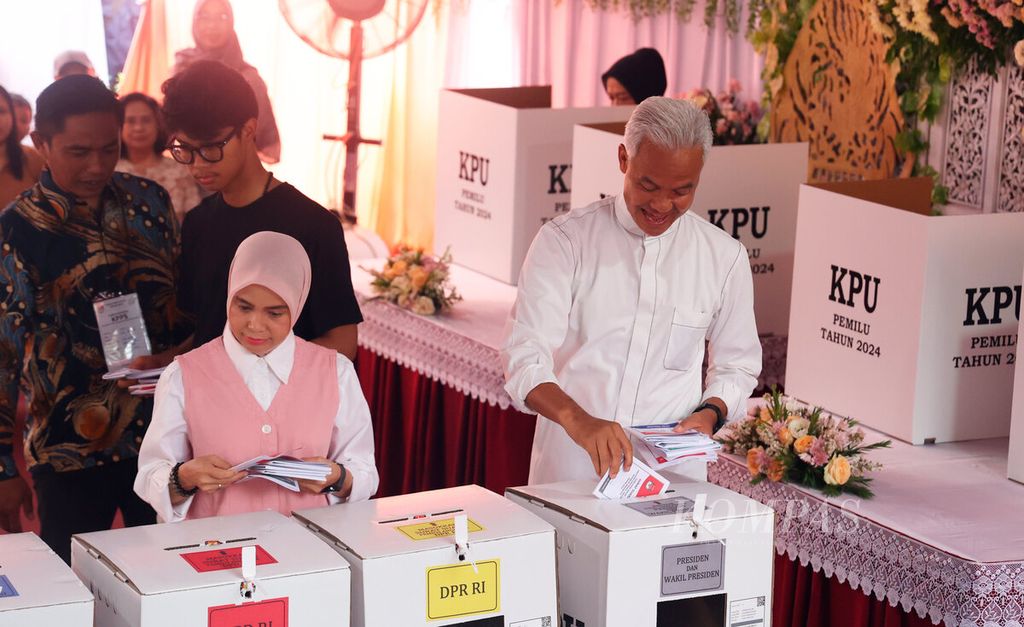 Calon presiden Ganjar Pranowo bersama istri, Siti Atikoh Suprianti, dan putranya, Muhammad Zinedine Alam Ganjar, saat memasukkan surat suara di TPS 11, Lempongsari, Kota Semarang, Jawa Tengah, Rabu (14/2/2024). 