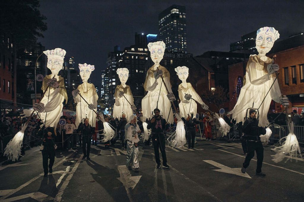 Orang-orang bersukaria berbaris di sepanjang Sixth Avenue selama Village Halloween Parade, Selasa (31/10/2023), di New York, AS. 