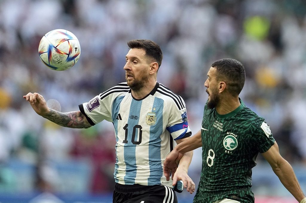Pemain timnas Argentina, Lionel Messi (kiri), berebut bola dengan pemain Arab Saudi Abdulelha Al-Malki pada laga penyisihan Grup C Piala Dunia Qatar 2022 di Stadion Lusail, Lusail, Qatar, Selasa (22/11/2022). Arab Saudi memenangi laga ini dengan skor 2-1. 
