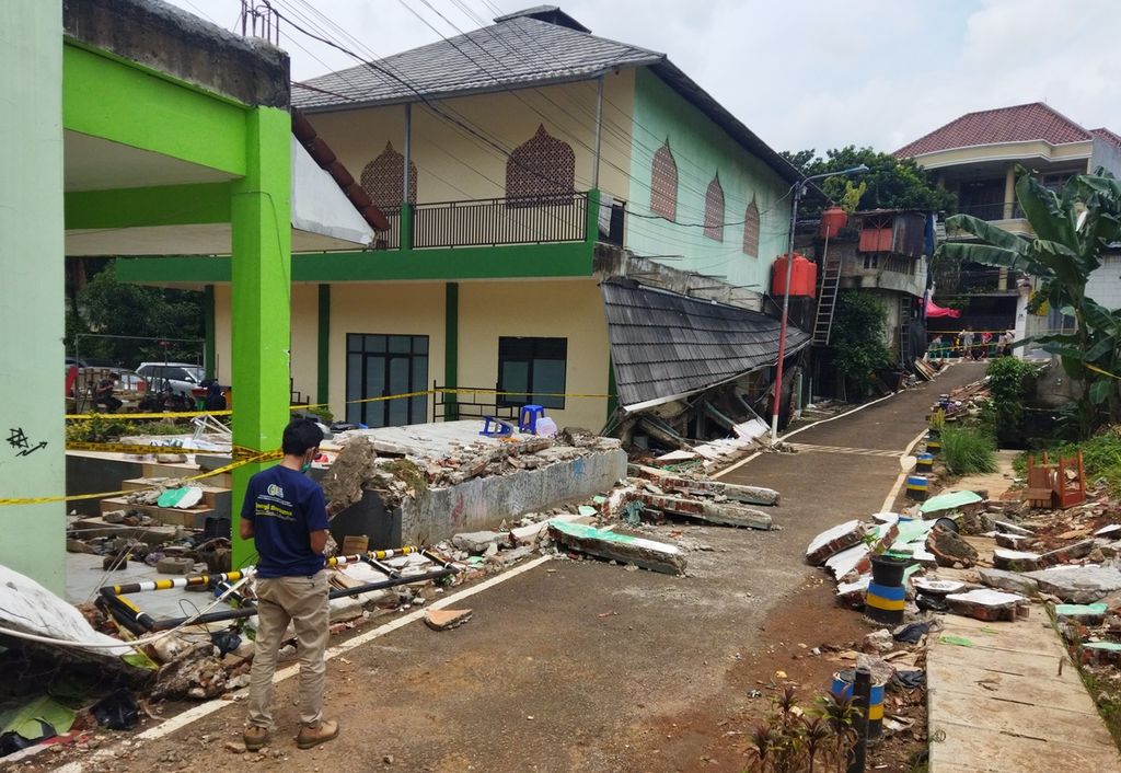Warga melintas di sisi tembok barat sekolah MTsN 19 di Jalan Kalijati, Kelurahan Pondok Labu, Kecamatan Cilandak, Jakarta Selatan, Jumat (7/10/2022). Lokasi sekolah berada di kawasan cekungan sehingga rawan banjir seperti yang terjadi pada Kamis (6/10/2022) siang yang menyebabkan tiga pelajar tewas.