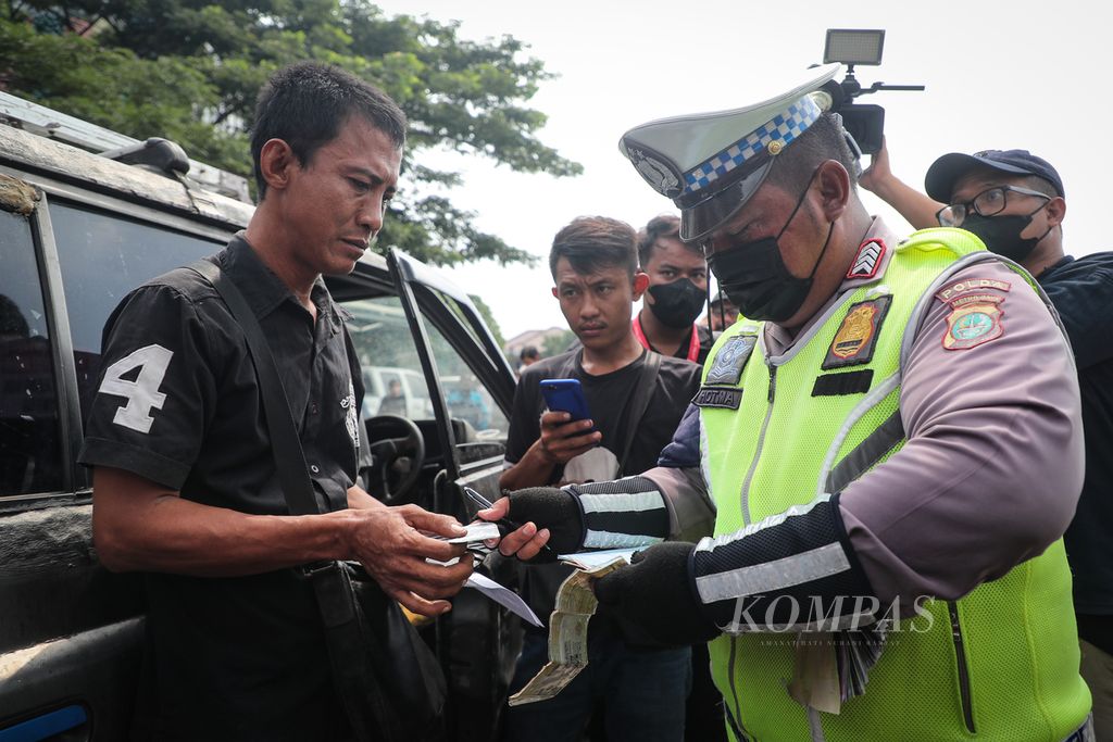 Polisi menilang pemilik mobil yang tidak lulus uji emisi di Jalan Perintis Kemerdekaan, Jakarta Timur, Rabu (1/11/2023). 