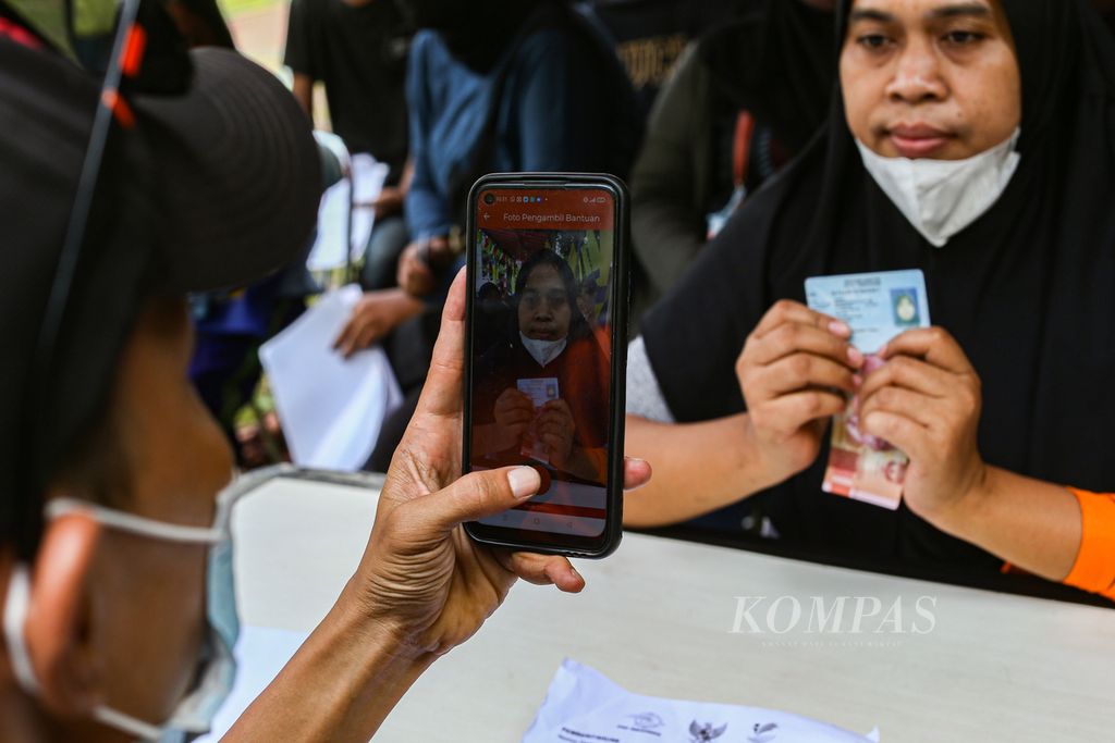 Petugas memotret warga yang penerima dana bantuan Program Sembako Tahun 2022 di kantor Kelurahan Larangan Utara, Larangan, Kota Tangerang, Banten, Kamis (3/3/2022). 