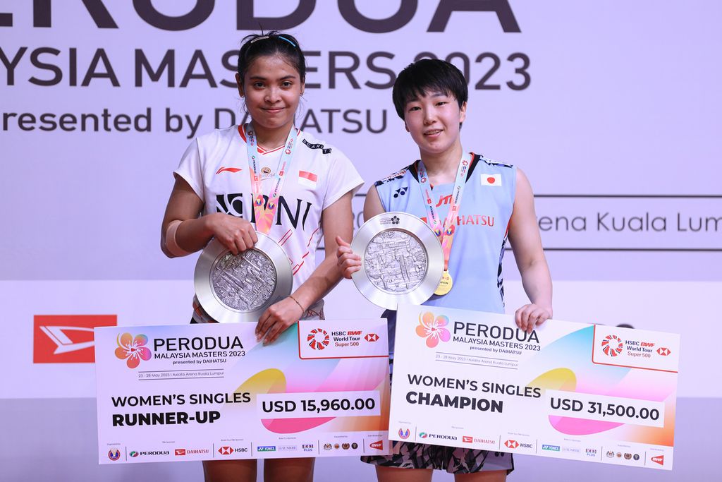 Gregoria Mariska Tunjung (kiri) dan Akane Yamaguchi (Jepang) di podium setelah laga final turnamen bulu tangkis Malaysia Masters 2023 di Kuala Lumpur, Malaysia, Minggu (28/5/2023).