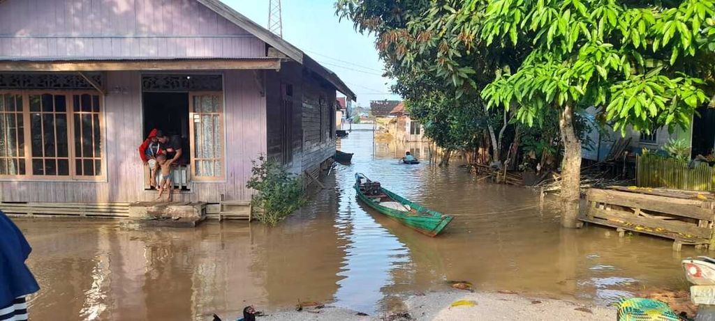 Warga Tumbang Samba, Kabupaten Katingan, harus menggunakan perahu bermesin untuk mobilitas di sekitar rumah karena banjir yang melanda wilayah tersebut, Minggu (7/8/2022).