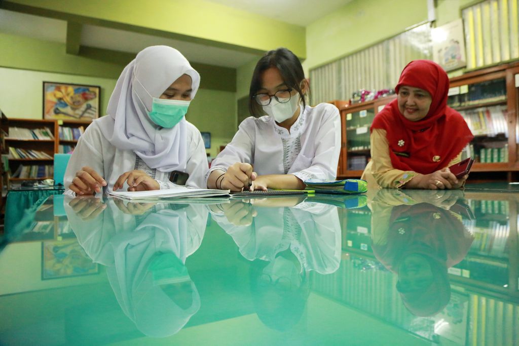Anak berkebutuhan khusus, Nabiilatunnajaah (kiri), mengajari teman sekelasnya untuk menggunakan Braille Note miliknya di SMAN 66 Jakarta, Cilandak, Jakarta Selatan, Jumat (02/11/2022). 