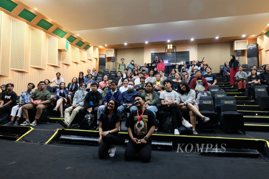Mengenakan kacamata dan kaus hitam, sineas Lola Amaria (depan tengah) berpose dengan audiens usai pemutaran film <i>Eksil</i> di gedung eks Bioskop Permata pada Selasa (6/12/2023). Pemutaran film ini adalah salah satu rangkaian kegiatan dari Festival Film Dokumenter (FFD) 2023 yang berlangsung pada 3-9 Desember 2023. Ada 84 film dari 42 negara yang ditayangkan di FFD 2023.