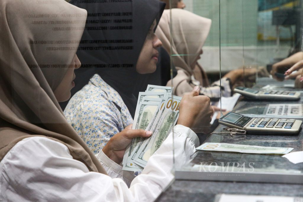Officials inspect US dollars exchanged at PT Valuta Artha Mas in Jakarta on Tuesday (16/4/2024). The officials said that the number of people selling US dollars has increased due to the strengthening of its exchange rate against the rupiah.