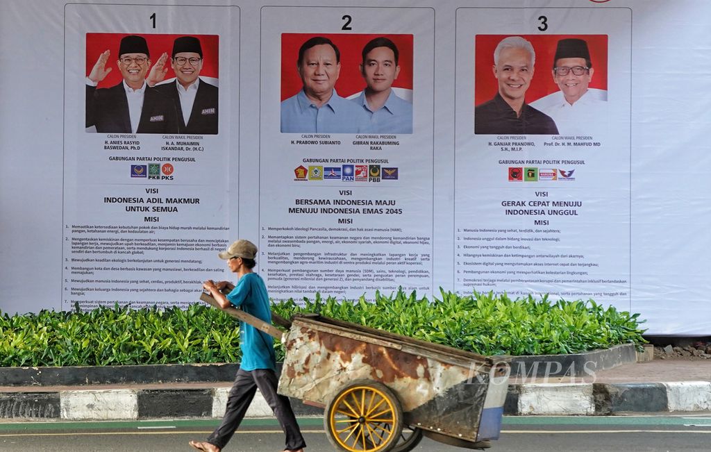 Warga melintasi poster sosialisasi Pemilu 2024 di sekitar Jembatan Layang Kuningan-Mampang, Jakarta, Selasa (9/1/2024).