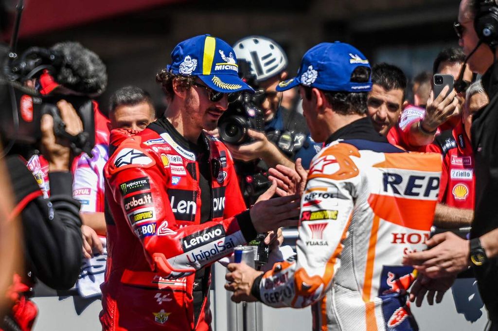 Pebalap Ducati Francesco Bagnaia (kiri) bersalaman dengan pebalap Honda Marc Marquez setelah sesi kualifikasi MotoGP seri Portugal di Sirkuit Internasional Algarve, Portimao, Sabtu (25/3/2023). Marquez membuat kejutan dengan meraih posisi start terdepan dalam kualifikasi. 