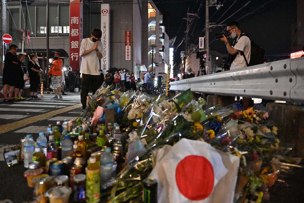 Seorang pria memberi penghormatan di lokasi penembakan mantan Perdana Menteri Jepang Shinzo Abe di luar Stasiun Yamato Saidaiji di Kota Nara. Abe dinyatakan meninggal di Rumah Sakit Universitas Nara tidak jauh dari tempat kejadian pada hari Jumat 8 Juli 2022.