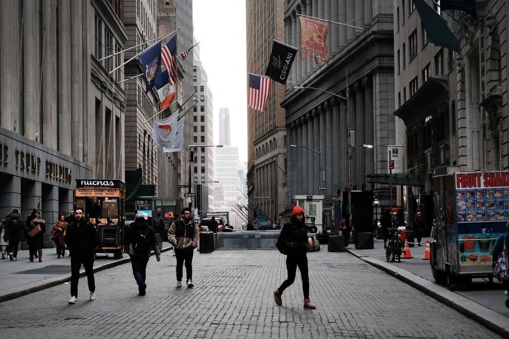 Sejumlah orang berjalan melintasi New York Stock Exchange (NYSE), Maret 2023.  