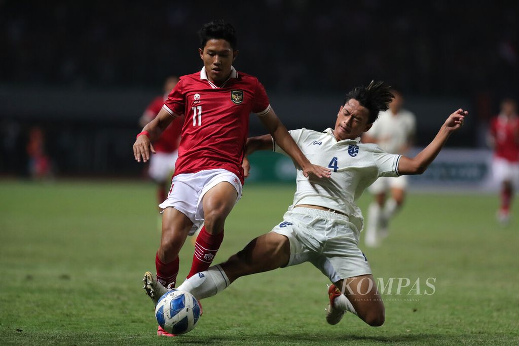 Pemain tim nasional Thailand, Theekawin Chansri (kanan), berusaha merebut bola dari penyerang sayap Tim Indonesia U-19, Ferdiansyah Cecep Surya, dalam laga penyisihan Grup A Piala AFF U19 2022 di Stadion Patriot Chandrabhaga, Bekasi, Jawa Barat, Rabu (6/7/2022). 