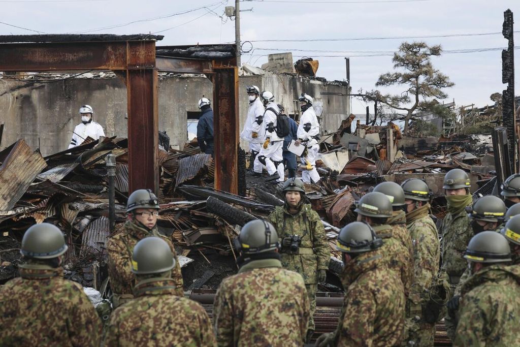 Anggota Pasukan Bela Diri Jepang mencari korban yang kemungkinan masih berada di bawah rumah-rumah yang runtuh di Wajima, Prefektur Ishikawa, Jepang, Kamis (11/1/2024). 