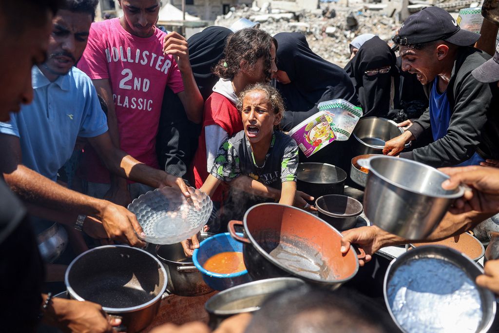 Seorang anak pengungsi berteriak meminta makanan saat pembagian makan di kamp Bureij untuk pengungsi Palestina di Jalur Gaza bagian tengah, Rabu (21/8/2024).