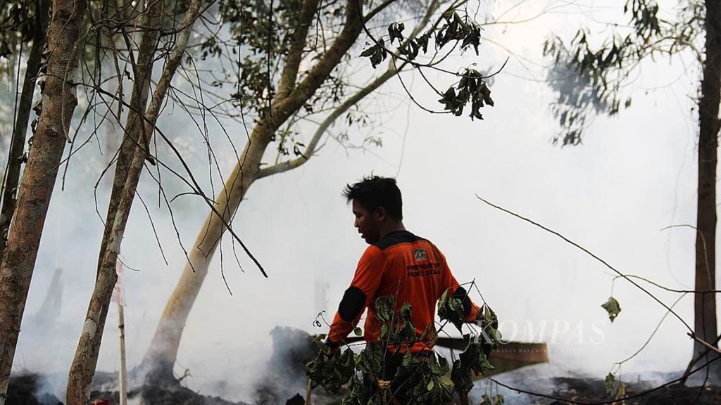 Petugas pemadam berupaya memadamkan kebakaran lahan di Pontianak, Kalimantan Barat, Rabu (15/8/2018).