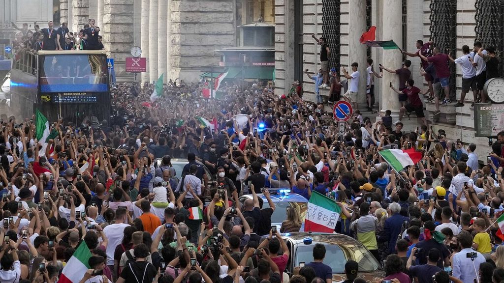Para pendukung memadati jalanan di Kota Roma, Italia, saat pemain timnas sepak bola Italia menggelar pawai juara Piala Eropa 2020, Selasa (13/7/2021) dini hari WIB. 