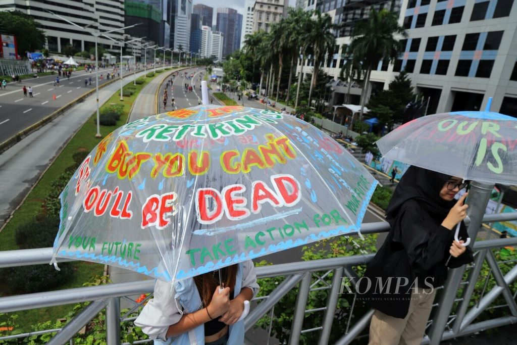Warga membawa payung aspirasi saat mengikuti aksi jeda untuk iklim di kawasan Jalan Jenderal Sudirman, Jakarta, Februari 2020.