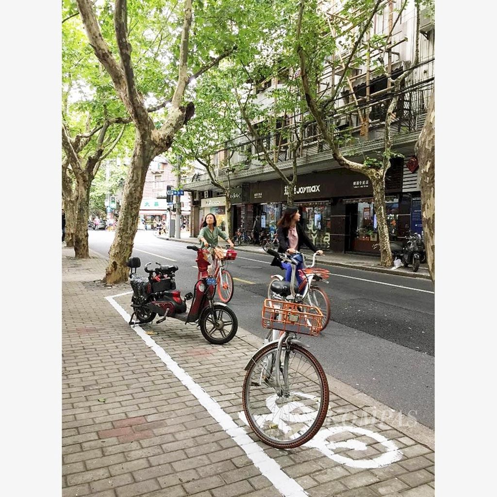 Di jalanan kota Shanghai dan kota-kota lain di China banyak warga menggunakan sepeda kayuh, sepeda listrik, dan sepeda motor listrik sebagai cara mengurangi polusi udara. Foto diambil pada 23 November 2017.