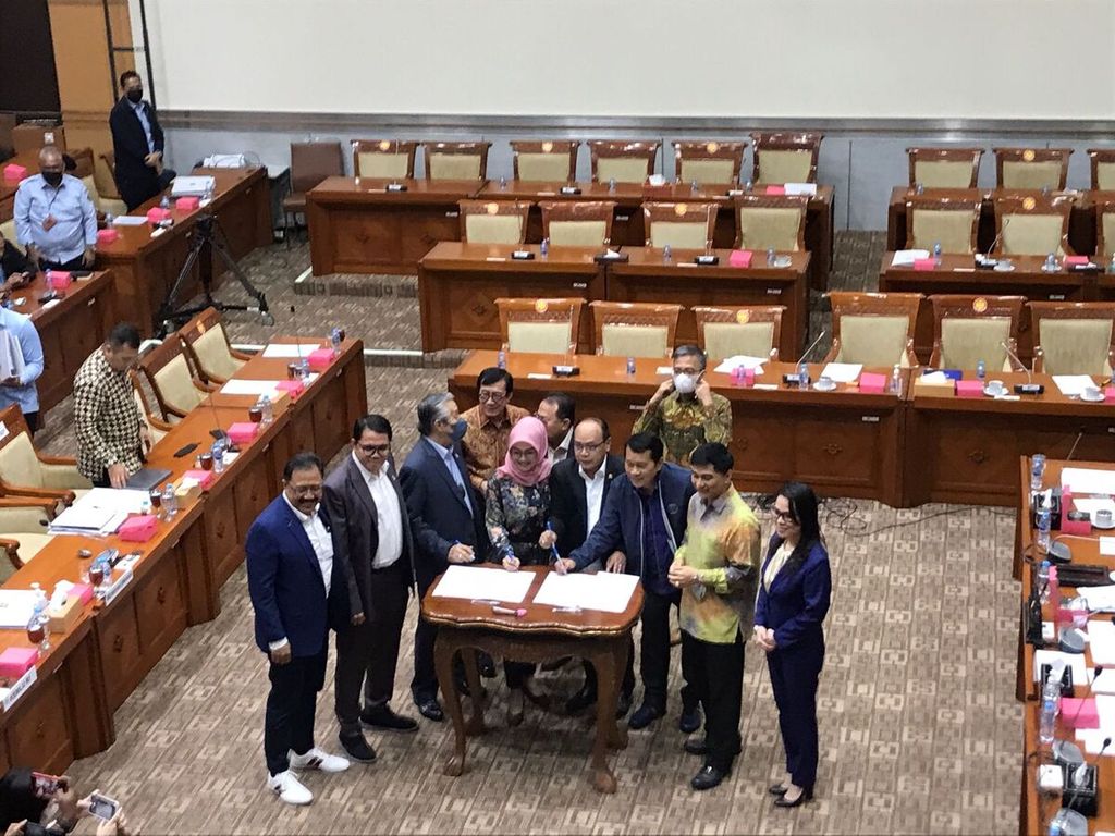 Sejumlah fraksi Komisi III DPR berpose dengan Menteri Hukum dan Hak Asasi Manusia Yasonna H Laoly seusai menyetujui pengesahan RUU Perjanjian Ekstradisi Indonesia-Singapura dalam pembahasan tingkat I di Kompleks Parlemen, Jakarta, Senin (5/12/2022).