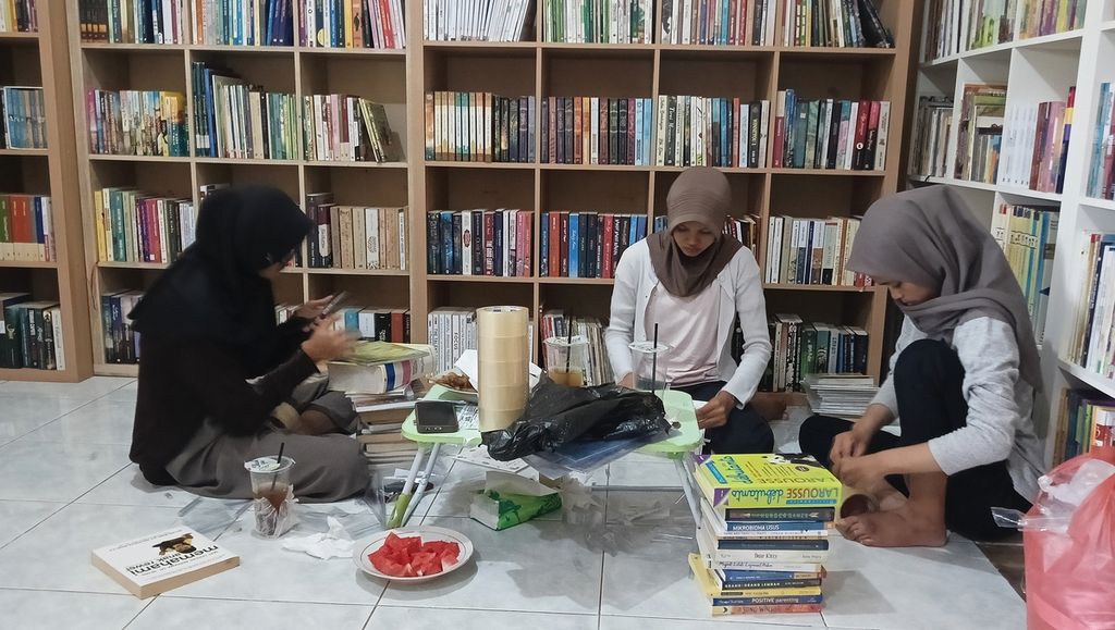 Tiga anak asuh sedang merapikan dan menyampul buku di rumah Britania Sari di Perumnas 2 Parung Panjang, Kabupaten Bogor, Jawa Barat, Sabtu (10/8/2024).