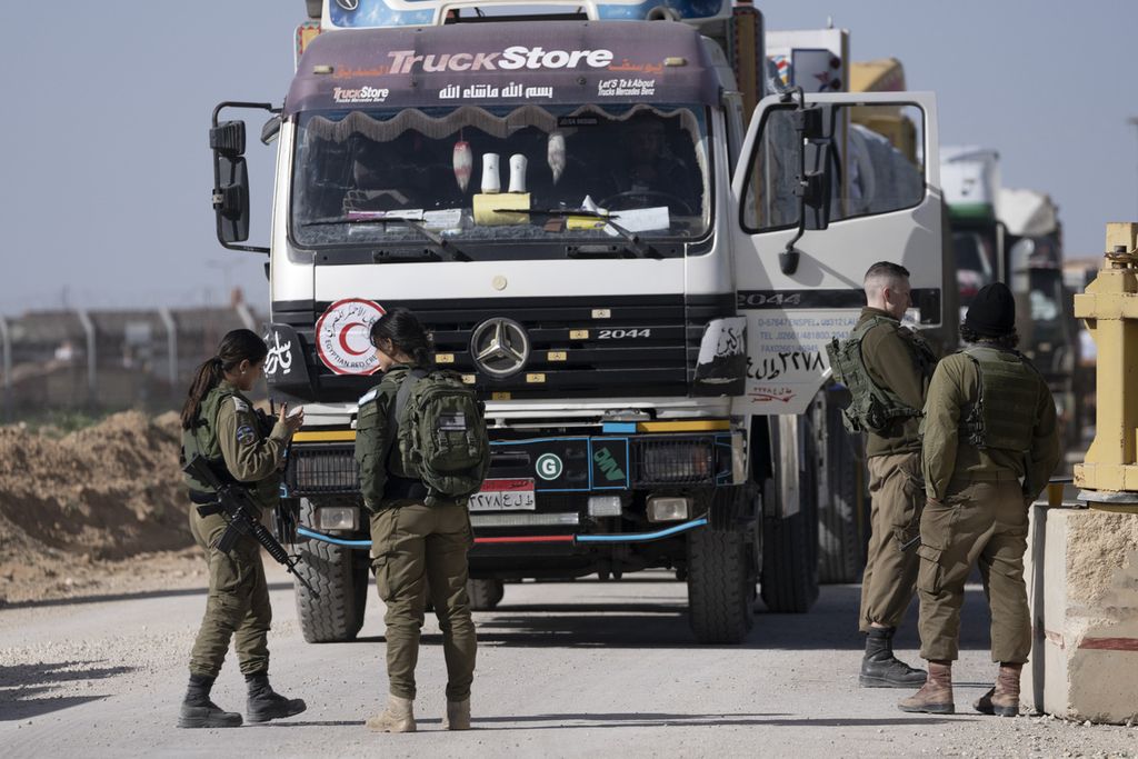 Beberapa personel militer Israel melakukan pemeriksaan truk bantuan kemanusiaan di pelintasan Kerem Shalom di selatan Israel, Jumat (22/12/2023). Program Pangan Dunia PBB menyebut 2,3 juta warga Gaza dalam kondisi kekurangan bahan pangan yang akut. 