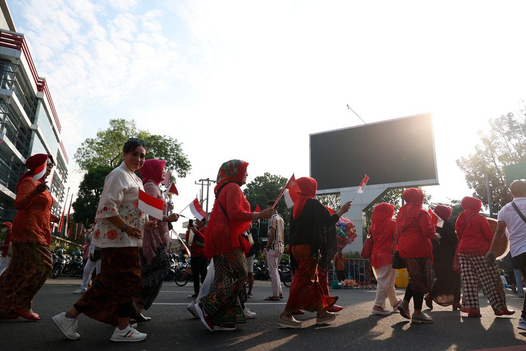 Perempuan dari berbagai komunitas berjalan mengenakan kebaya untuk memeriahkan HUT Ke-77 RI di Lodji Gandrung, Kota Surakarta, Jawa Tengah, Minggu (14/8/2022). Mereka mengenalkan kebaya sebagai bagian dari tren mode yang berkiblat pada budaya. 
