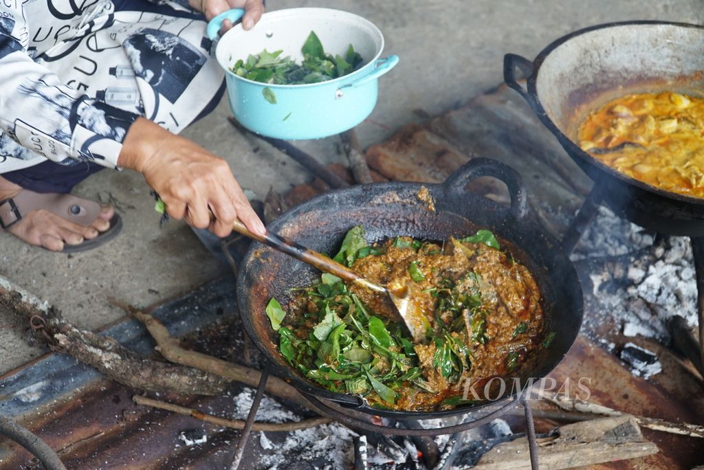 Jusdahniar (57) cooks rendang leaves at his home in Nagari Batu Bulek, North Lintau Buo District, Tanah Datar, West Sumatra, Saturday (28/5/2022). Lintau's signature rendang uses ingredients from the 50's to 100's of types of leaves and eels..