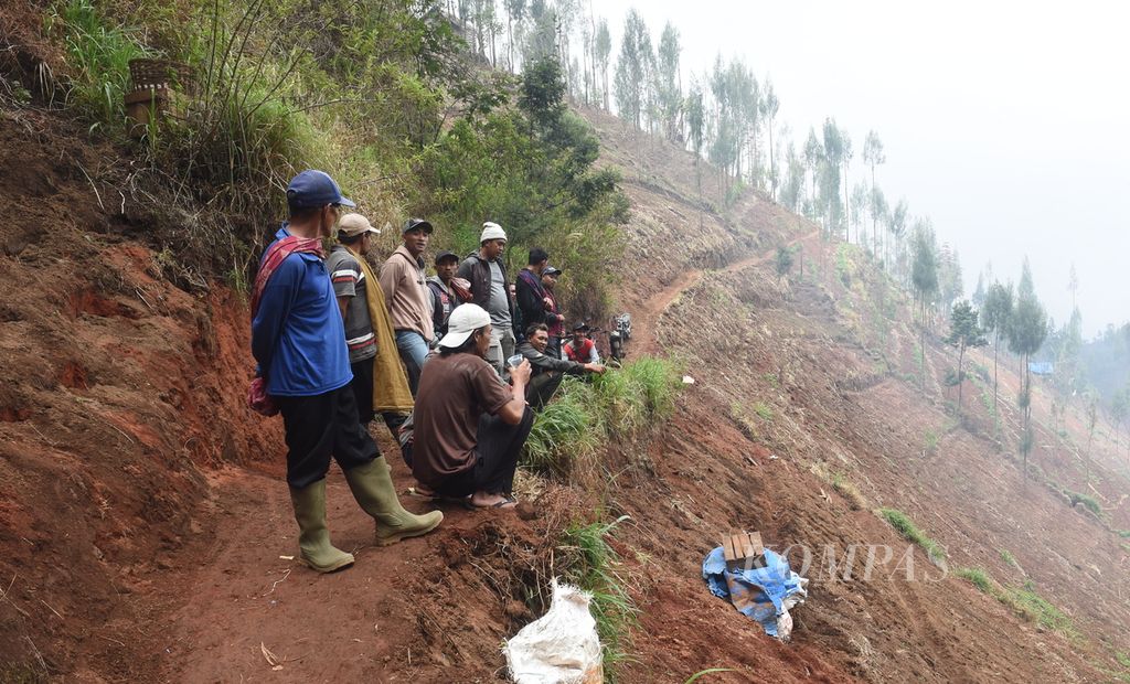 Warga melihat dari kejauhan lokasi jatuhnya satu dari dua pesawat TNI AU, Super Tucano, Skuadron Udara 21 di lereng pegunungan Bromo, Desa Keduwung, Kecamatan Puspo, Kabupaten Pasuruan, Jawa Timur, Jumat (17/7/2023).
