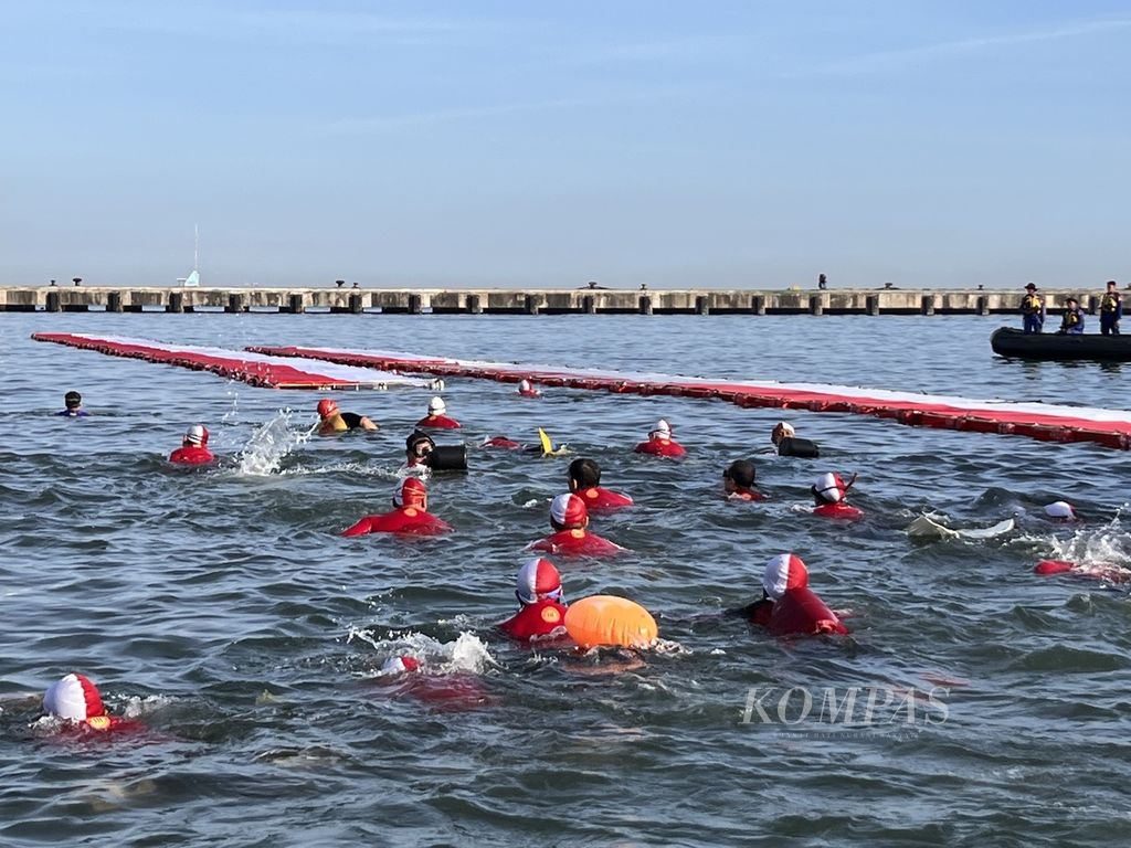 Peserta antusias berenang menuju bendera yang kemudian diarak dari Makassar ke Pulau Gusung, Sabtu (12/8/2023).