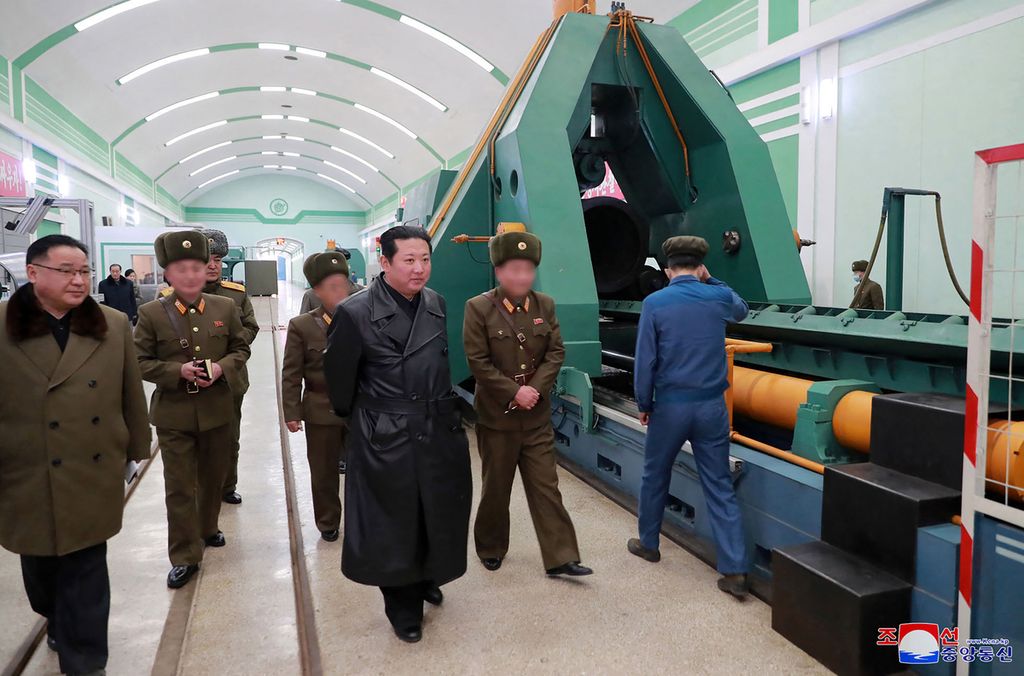 Foto tanpa tanggal yang dirilis kantor berita resmi Korea Utara, KCNA, pada 28 Januari 2022 menunjukkan Pemimpin Korut Kim Jong Un (tengah) menginspeksi pabrik senjata di lokasi yang dirahasiakan. 