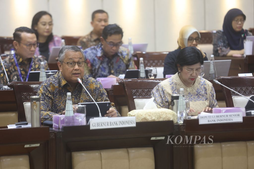 Gubernur Bank Indonesia Perry Warjiyo (kiri) didampingi Deputi Bank Indonesia Destry Damayanti mengikuti rapat kerja dengan Komisi XI DPR di Kompleks Parlemen, Senayan, Jakarta, Kamis (12/9/2024). 