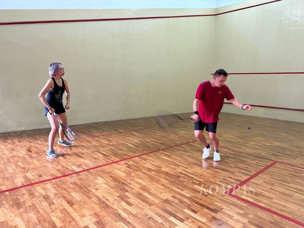 Atillah (44), warga Hongaria (kanan), dan temannya, Ochie (43), memilih berolahraga dalam ruangan, squash, untuk memenuhi kebutuhan olahraga hariannya di tengah polusi udara Jakarta. 