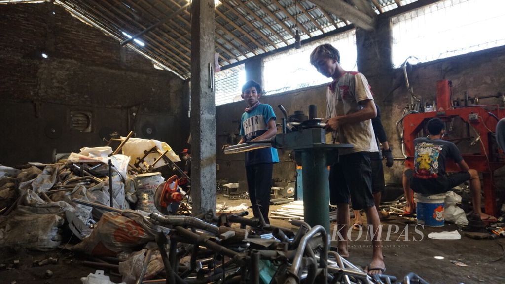 Pekerja sedang menyelesaikan pembuatan knalpot di industri rumah tangga di Desa Kembaran Kulon, Kabupaten Purbalingga, Jawa Tengah, Kamis (25/7/2019). Pembuatan knalpot secara manual menyerap banyak tenaga kerja, tetapi perlu peningkatan kualitas untuk dapat memenuhi kebutuhan industri otomotif besar.