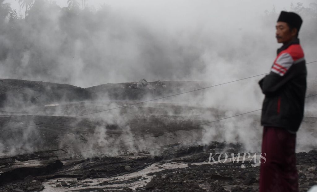 Warga mengamati Besuk Kobokan yang dipenuhi material vulkanik yang mengeluarkan asap pascaerupsi Gunung Semeru di Desa Supiturang, Kecamatan Pronojiwo, Kabupaten Lumajang, Jawa Timur, Minggu (4/12/2022). 