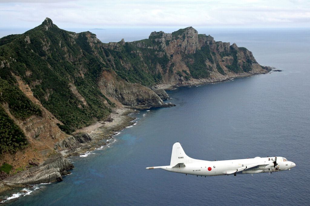 Dalam foto bertanggal 13 Oktober 2011 ini, pesawat pengintai angkatan laut Jepang terbang di atas Pulau Senkaku atau yang oleh China disebut sebagai Pulau Diaoyu. Wilayah ini diperebutkan kedua negara. 