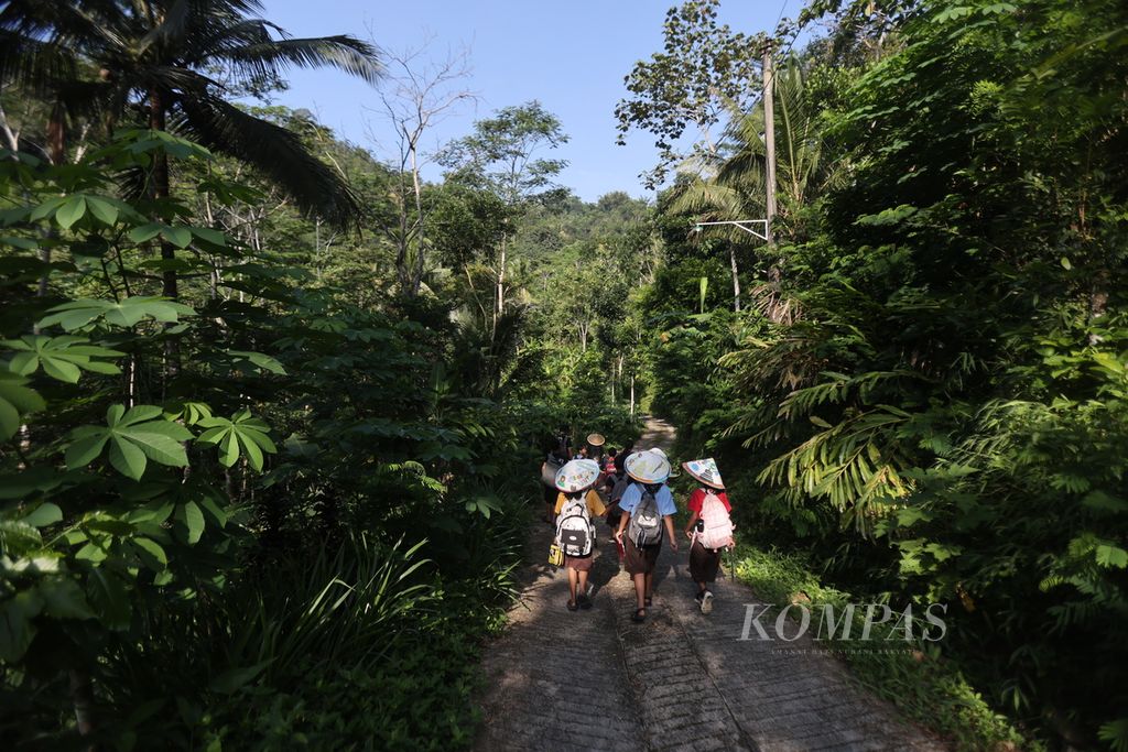 Murid SD Kanisius Kenalan berjalan menuju Belik Ploso dalam kegiatan Tilik Belik di Dusun Kerugbatur, Desa Majaksingi, Kecamatan Borobudur, Magelang, Jawa Tengah, Kamis (21/3/2024). 