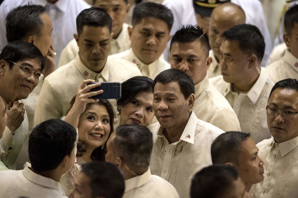 Presiden Filipina Rodrigo Duterte melayani swafoto dengan salah satu warga seusai menyampaikan pidatonya di depan Kongres di Manila, Senin (23/7/2018). Di tengah kritik keras atas program-programnya, popularitas Duterte tetap tinggi di mata publik Filipina.