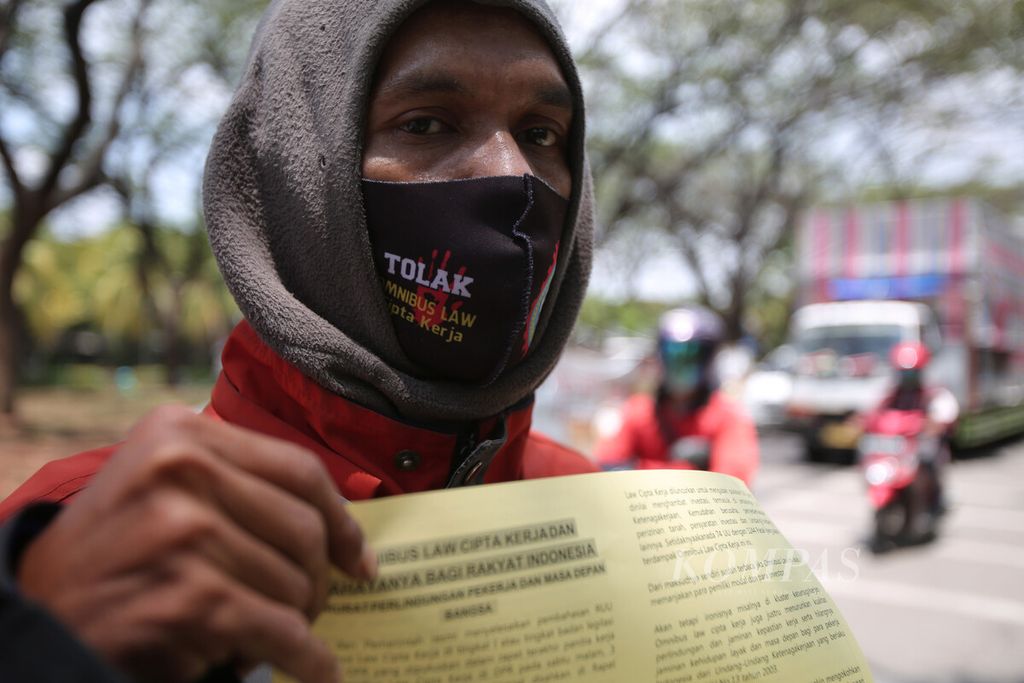 Buruh membagikan 1.000 pamflet berisi penolakan RUU Cipta Kerja kepada pengguna jalan di Jalan MH Thamrin, Cikarang Selatan, Kabupaten Bekasi, Jawa Barat, Rabu (7/10/2020). 