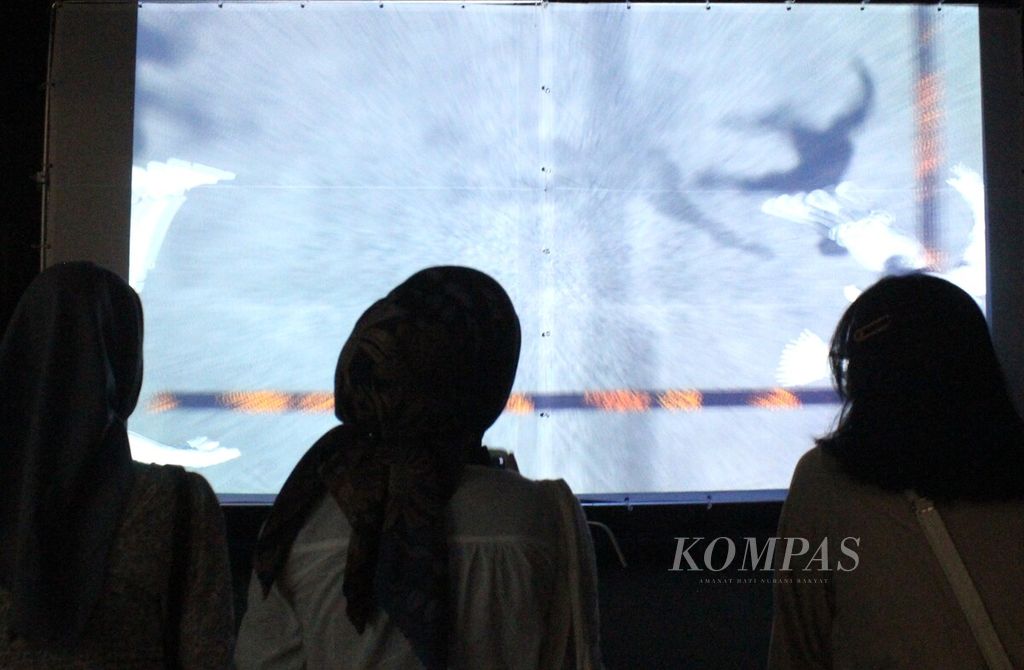 Pengunjung mengamati seni video instalasi ”Aku, Chairil!” yang diproduksi Miles Films dalam pameran seni kontemporer artina#2: matrajiva, di Gedung Sarinah, Jakarta, Jumat (28/4/2023). 