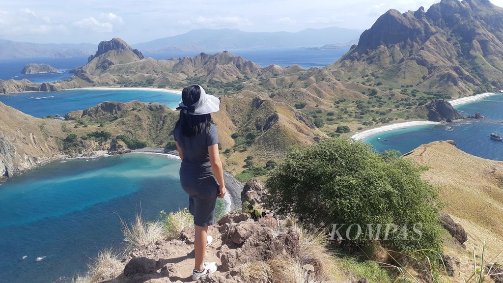 Wisatawan menikmati panorama alam dari puncak Pulau Padar, Kabupaten Manggarai Barat, NTT, pada Jumat (24/6/2022). Pulau Padar berada dalam wilayah Tanam Nasional Komodo. 