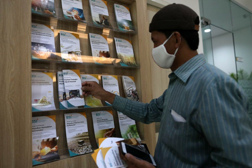 Nasabah mencari informasi tentang Bank Syariah Indonesia di Kantor Cabang Hasanudin, Blok M, Jakarta, Senin (1/2/2021). Bank yang merupakan hasil merger dari PT Bank BRI Syariah Tbk, PT Bank BNI Syariah, dan PT Bank Syariah Mandiri tersebut, resmi beroperasi pada Senin (1/2/2021). Bank beraset Rp 240 triliun ini diharapkan dapat memberikan efek domino bagi ekonomi syariah dan rantai pasok industri halal dalam negeri. BSI saat ini berada di posisi ke-7 dalam daftar sepuluh besar bank terbesar di Indonesia dari sisi aset.