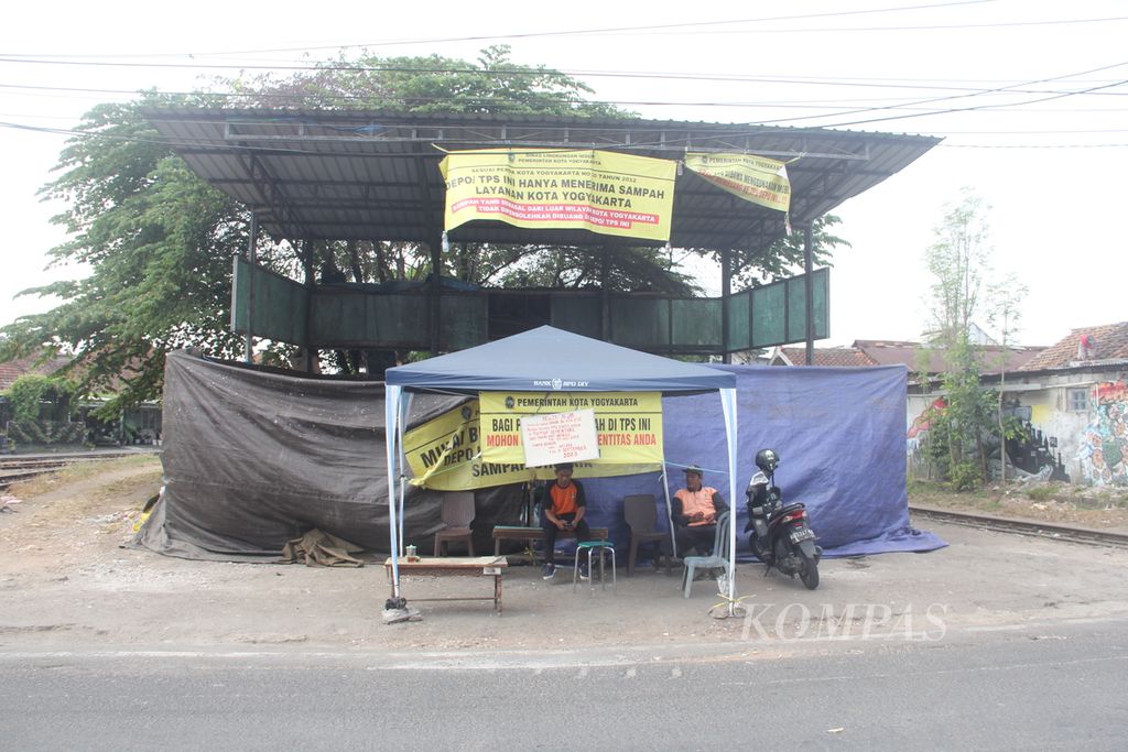 Petugas berjaga di depan tempat penampungan sementara sampah di wilayah Kecamatan Gondokusuman, Kota Yogyakarta, yang tutup dan tidak melayani pembuangan sampah, Senin (24/7/2023). 
