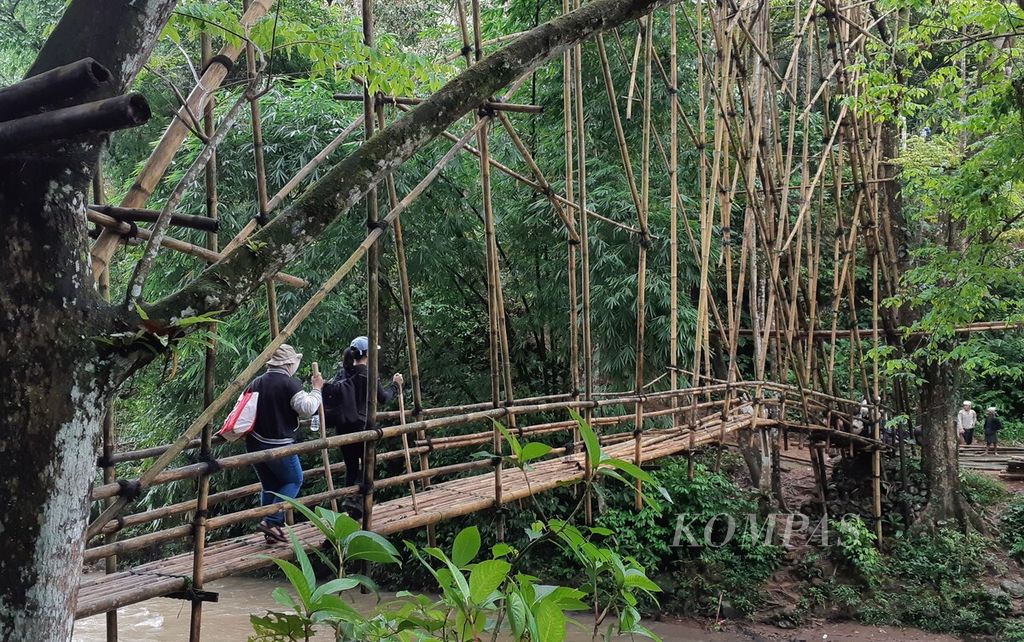 Pengunjung menyeberangi jembatan bambu untuk masuk ke Kampung Cibeo di daerah Baduy Dalam, Desa Kanekes, Kecamatan Leuwidamar, Kabupaten Lebak, Banten, Sabtu (10/2/2024).  