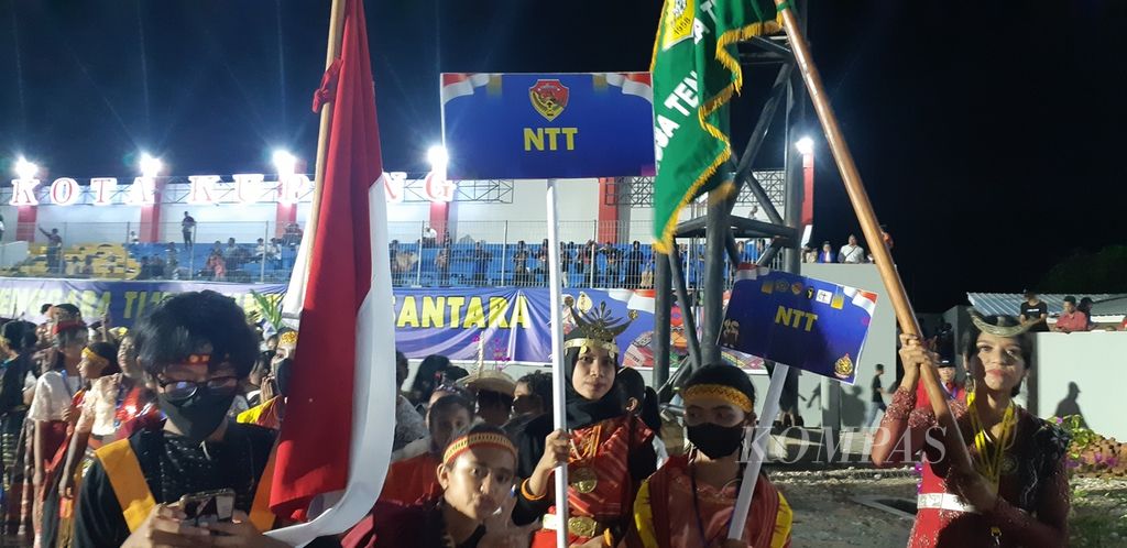 Seorang gadis Muslim membawa papan nama provinsi saat defile kontingen dalam acara pembukaan Pesparani Nasional II di Kota Kupang, Nusa Tenggara Timur, pada Jumat (28/10/2022). Keterlibatan umat lintas agama menunjukkan bukti persaudaraan masyarakat NTT. 