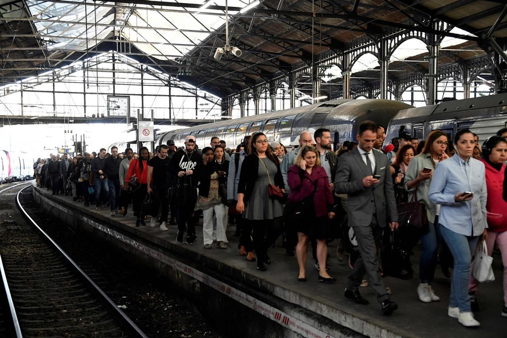 Dalam foto yang diambil pada 24 April 2018 ini tampak para penglaju berjalan di peron setelah melakukan perjalanan menggunakan kereta RER di Stasiun Saint-Lazare, Paris, Perancis. 